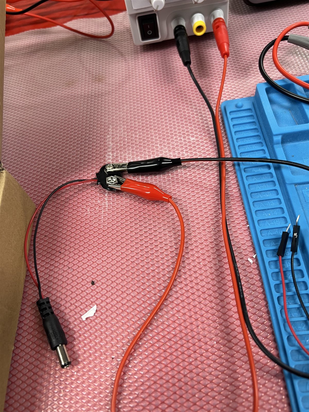 Alligator clips attached to the exposed terminals of a 9V battery snap