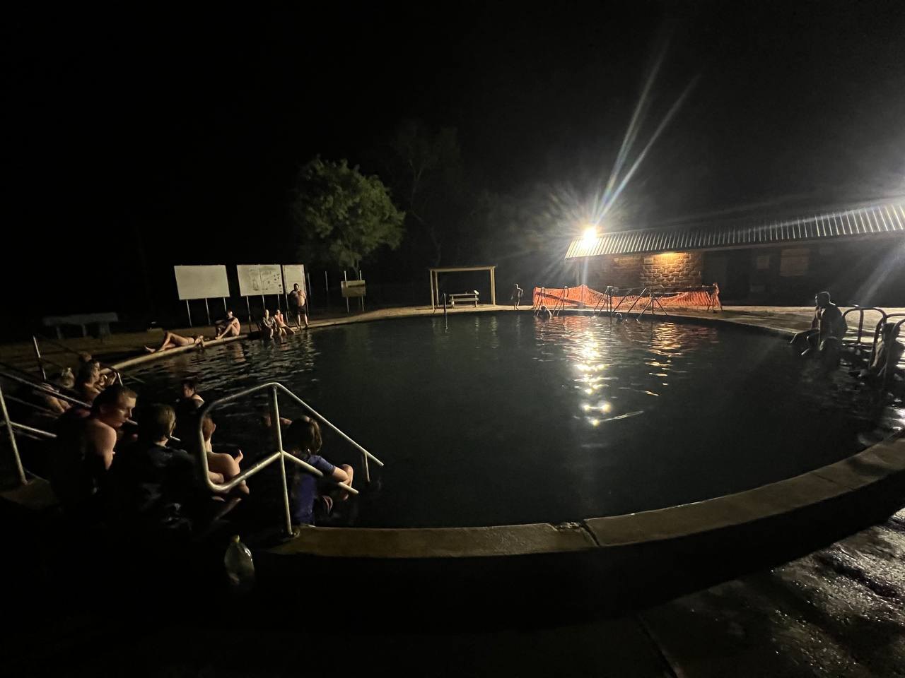 Bathers around the edge of the Lightning Ridge bore baths after dark